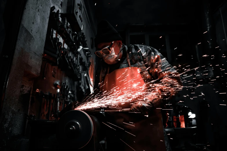 an industrial worker using grinders to cut steel