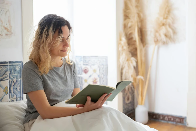 woman sitting down reading a book about being kindle