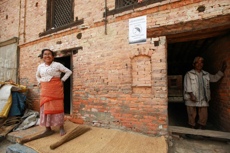 a woman standing at the doorway to a brick building
