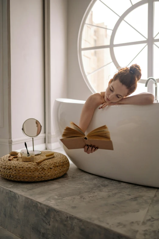 a woman laying in a bathtub next to a clock