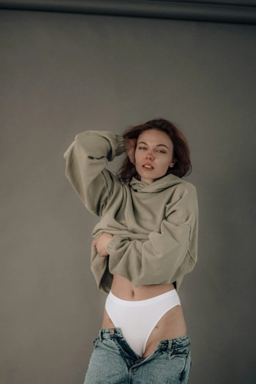 a young woman is posing with her hands on her head