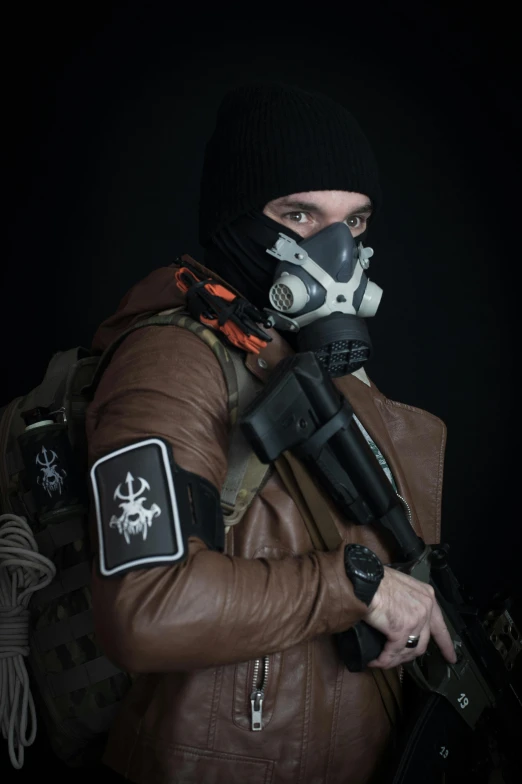 man with gun and gas mask wearing brown jacket