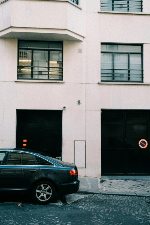 a black car parked in front of a white building