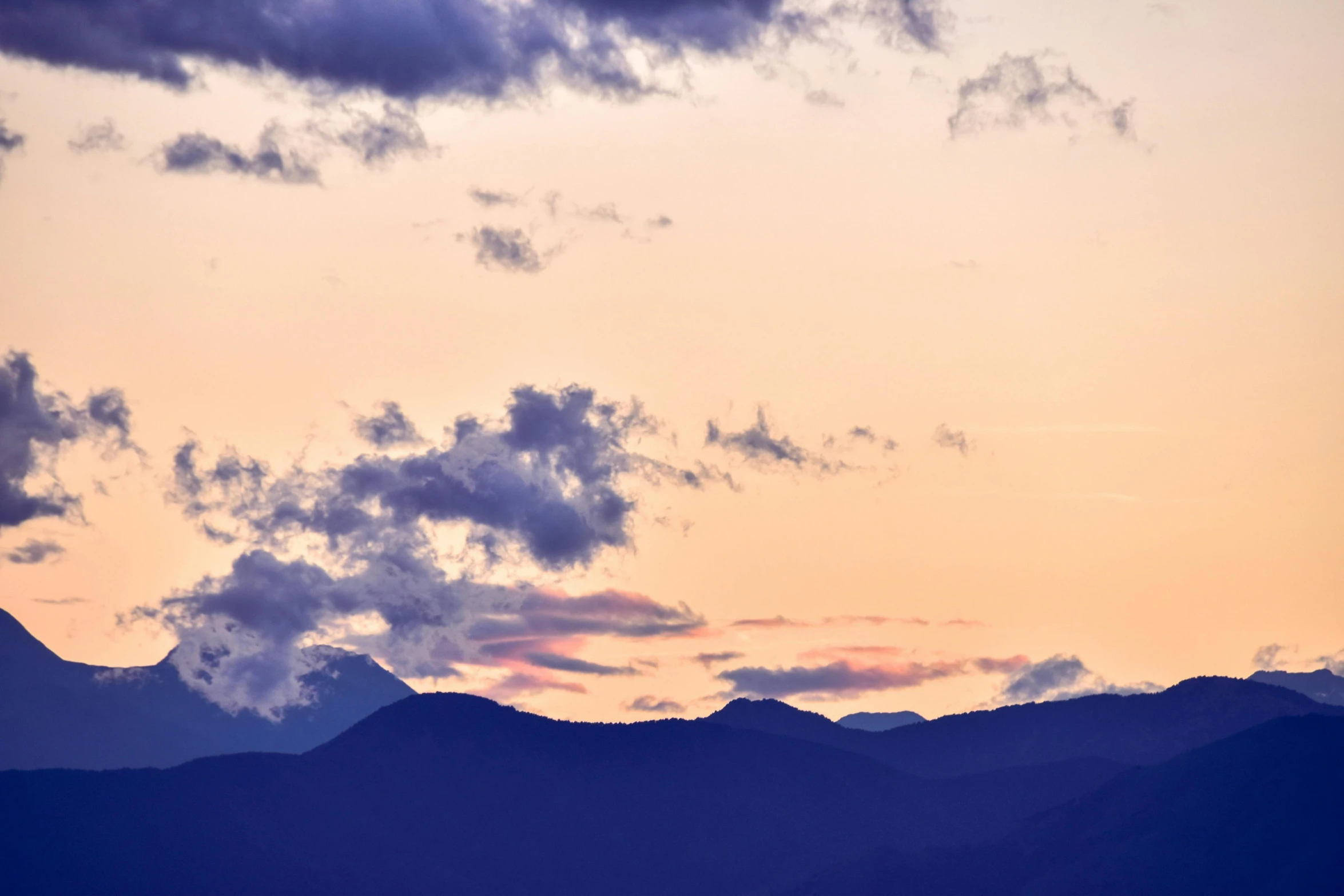 silhouette of hills and clouds on dusk sky