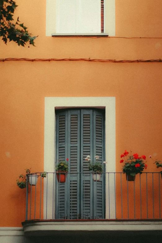 the front of a building that has two doors and a balcony