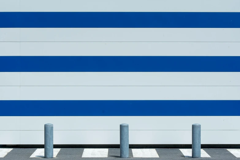 two metal posts and a blue striped wall