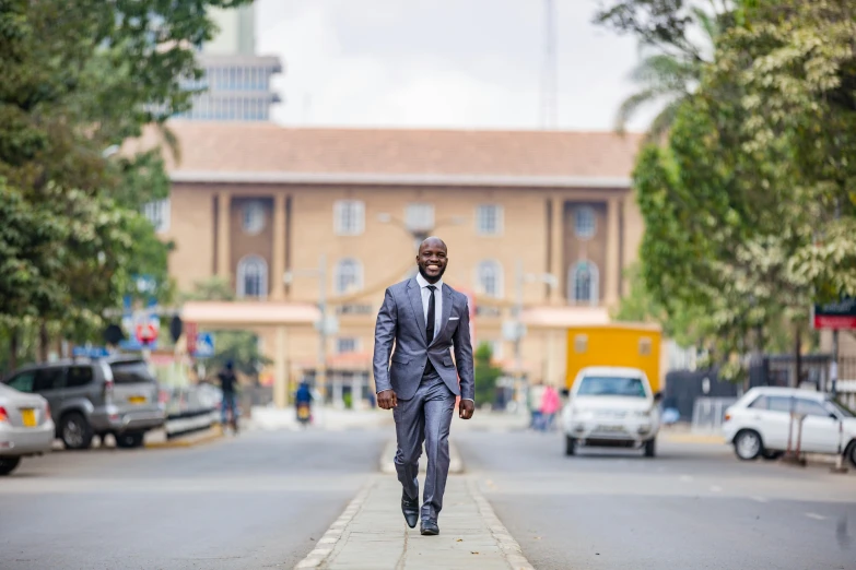 a man in a grey suit and tie walking down the street