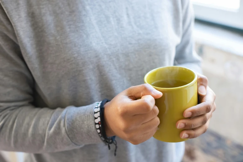 a close up of a person holding a cup