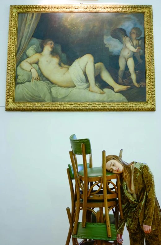 a wooden rocking chair with green chairs and a painting above it