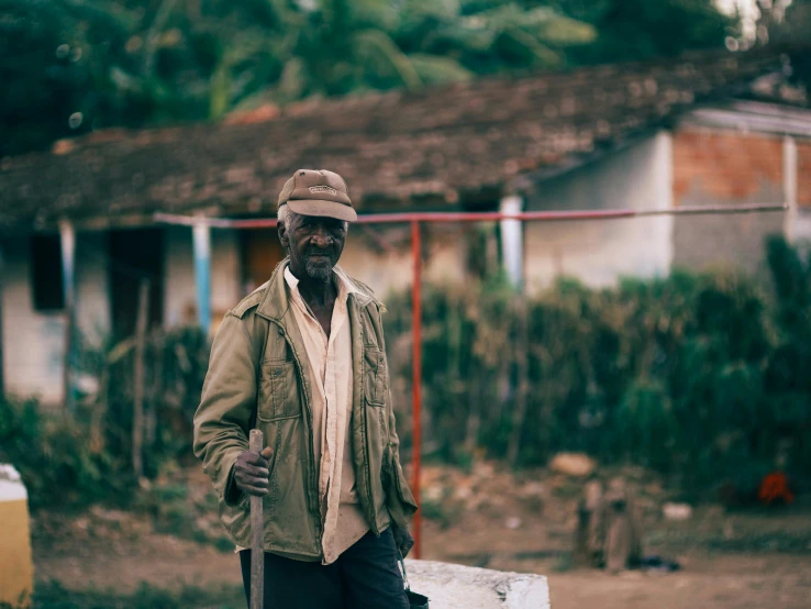 a man with a cane standing outside of a house