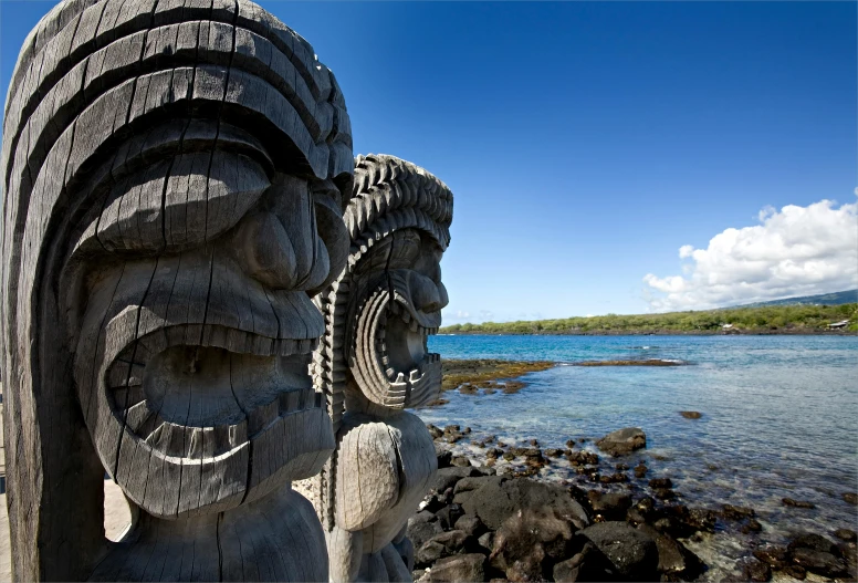 a sculpture of a face and other items by a lake