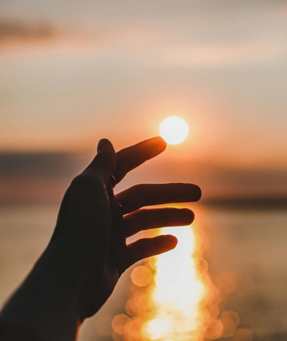 a person is holding their finger up against the sun