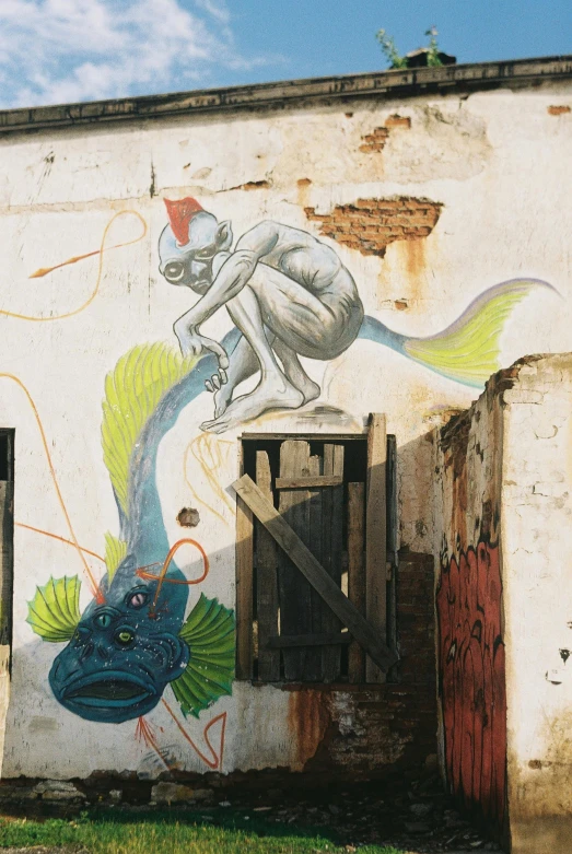 a painted wall with fish next to the building