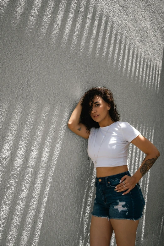 a young woman standing in front of a wall