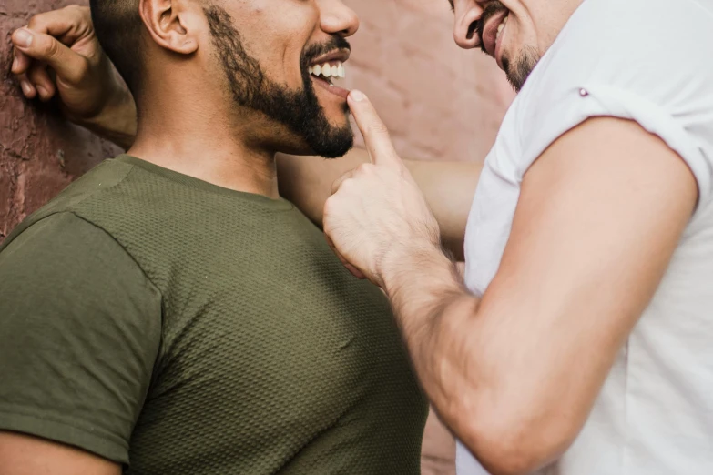 a man getting his teeth brushed next to another man