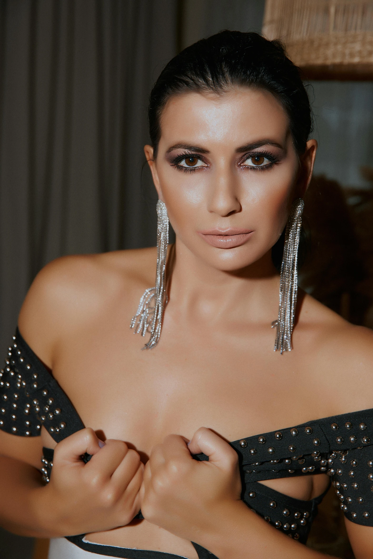 a woman in a black and white dress with big silver earrings