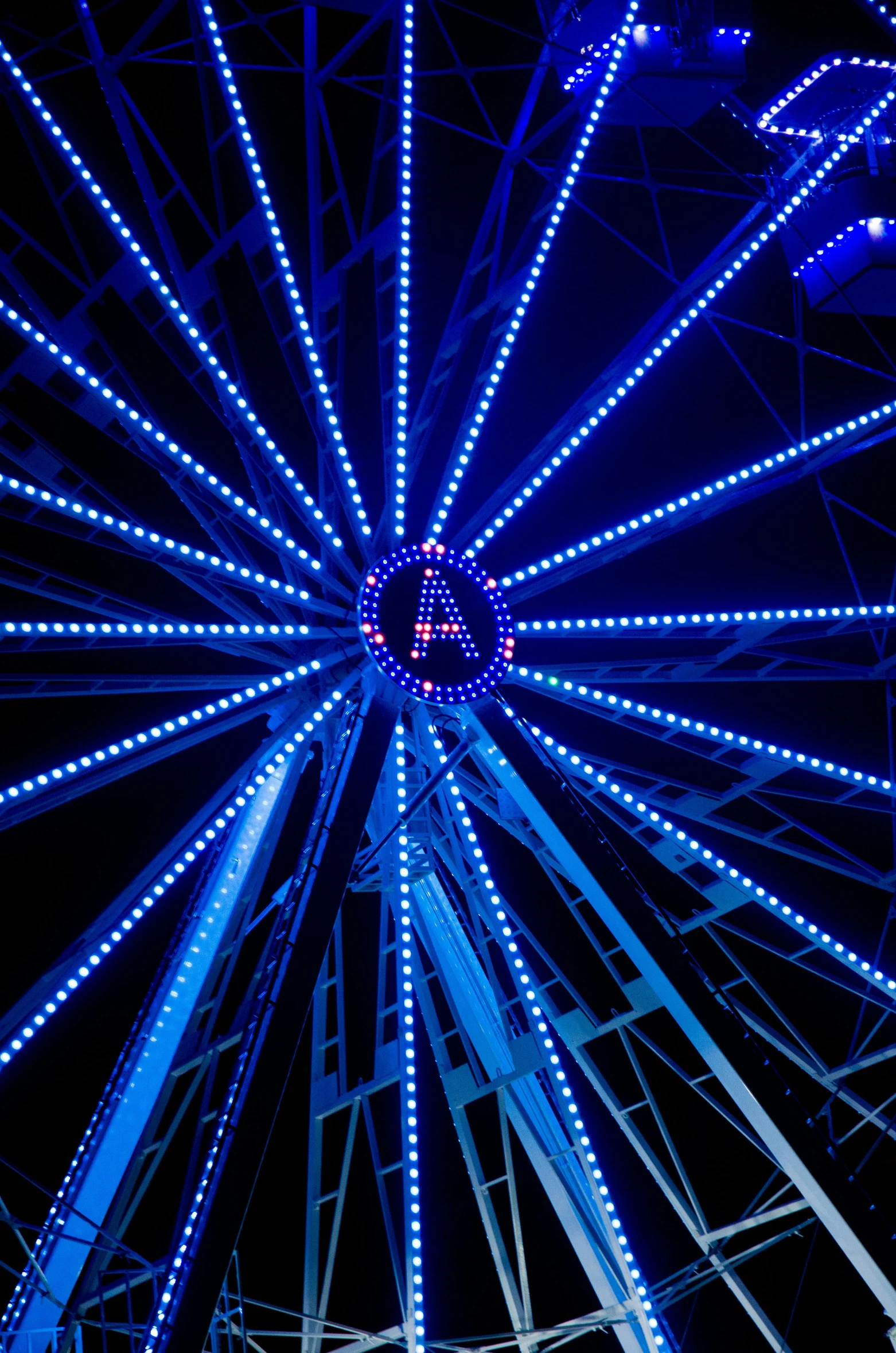 the large white light up ferris wheel at night