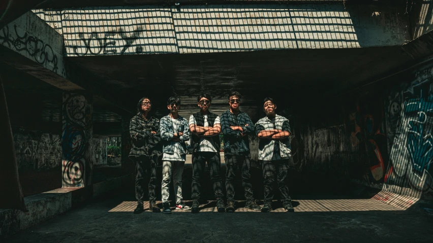 four men stand in an empty alley way