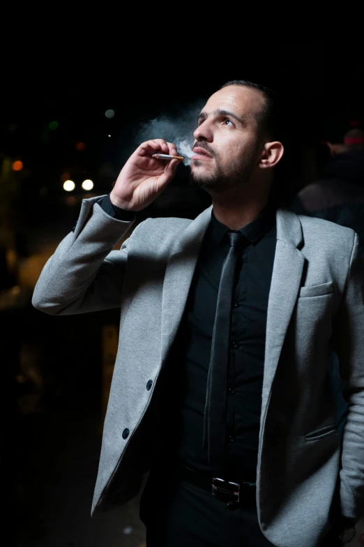 a man smoking cigarette next to a building
