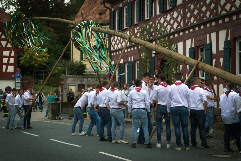 a group of people in white shirts carrying colorful ribbons