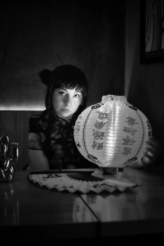 a young woman with a geisha doll and lamp