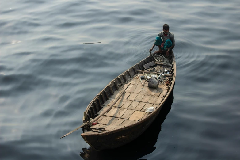 a man sits on the bow of a small boat