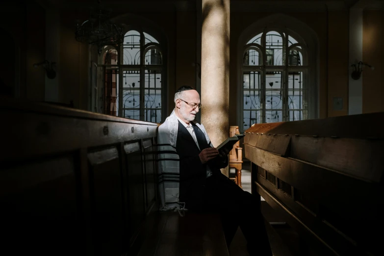 a man sitting in the middle of a church looking at his cell phone