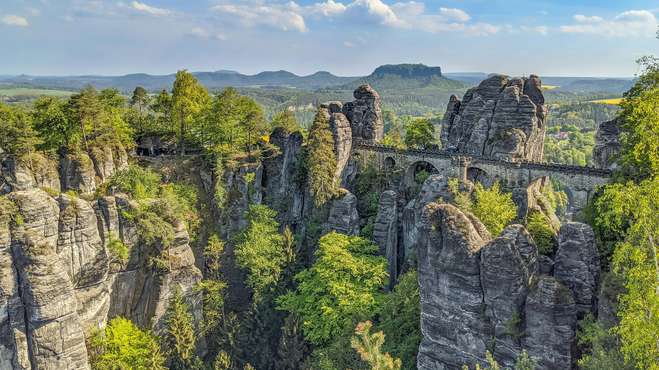 a mountain forest with several towers of rock formation, and trees