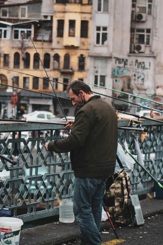 a man with fishing rods looking over a bridge