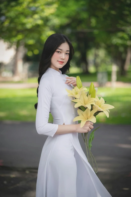 a young lady is holding flowers in her hands