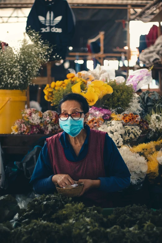 an old woman with a face mask on looking at her phone