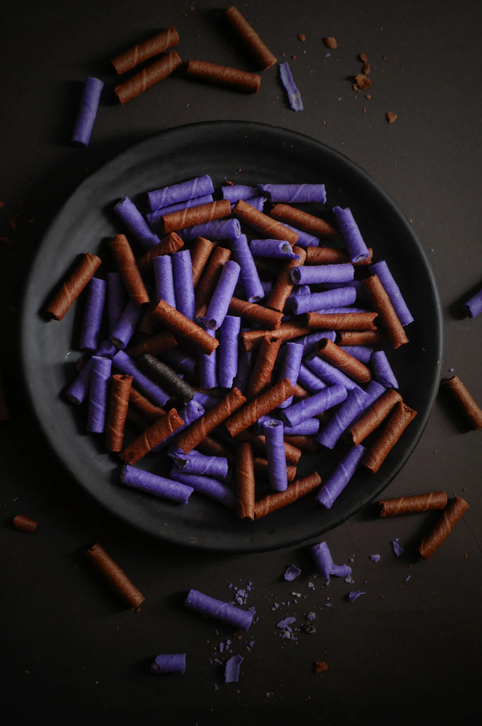 a plate filled with carrots and brown and purple sticks