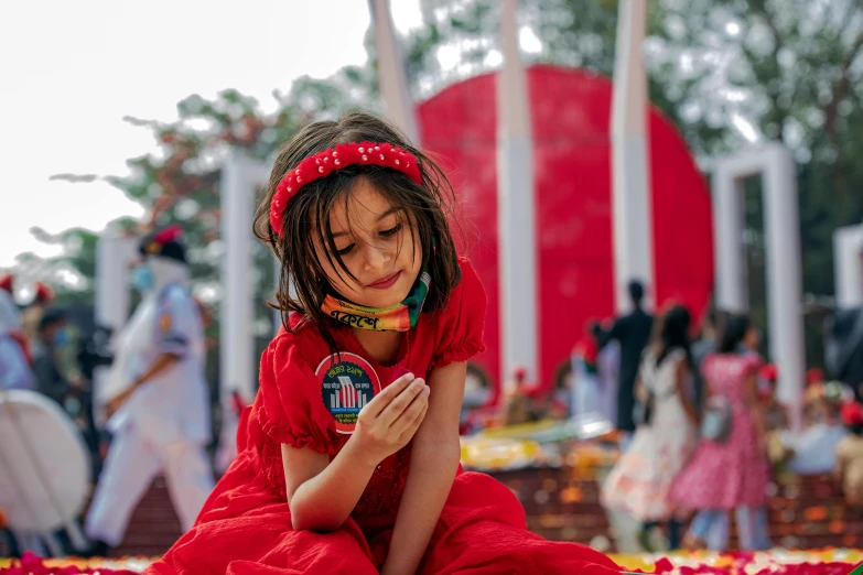 a little girl sitting down on the ground