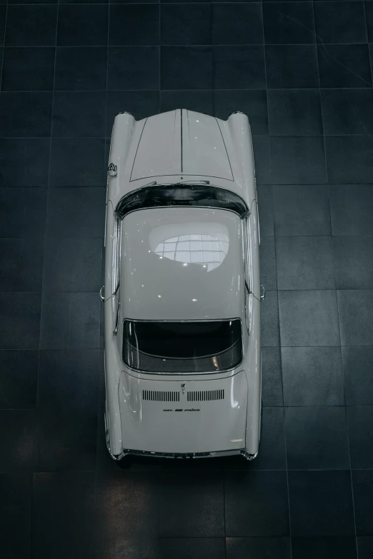 a vintage mercedes benz coupe on a black tiled floor