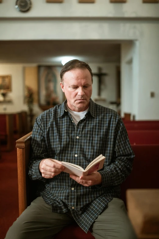 a man sitting in a chair reading a book