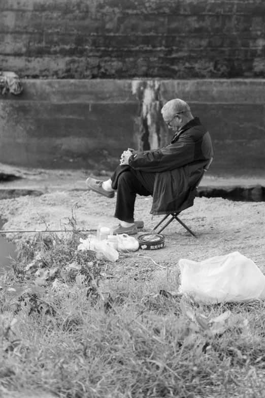 a man sitting in a chair with bags outside