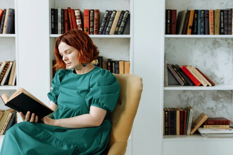 woman reading a book sitting on a leather chair