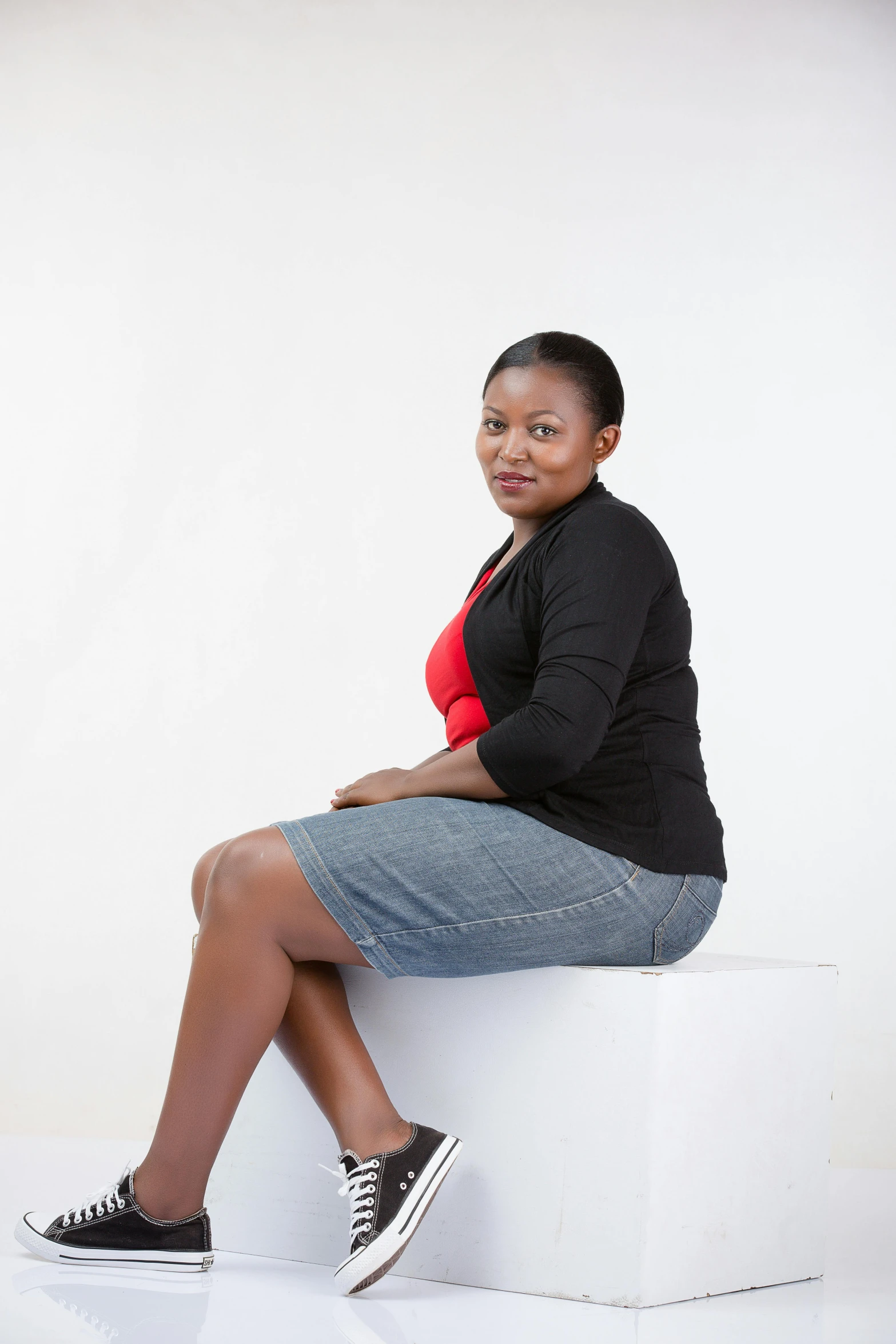 a woman is sitting on top of a cube and posing for the camera