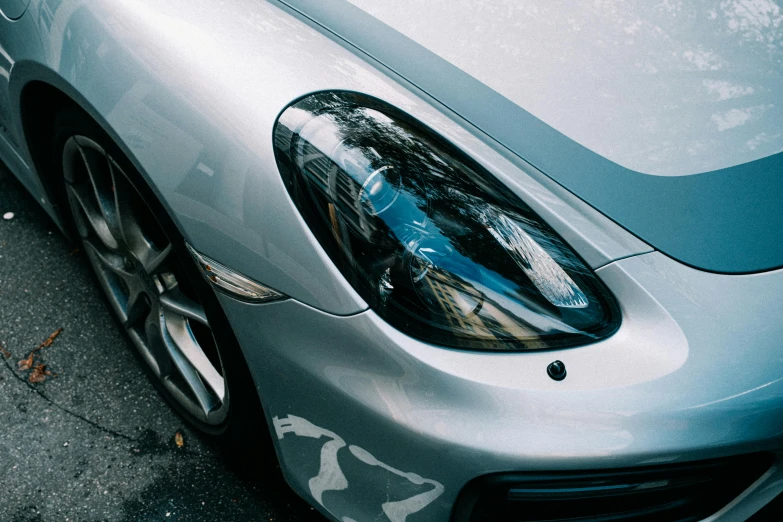 the front view of a silver porsche in a parking space