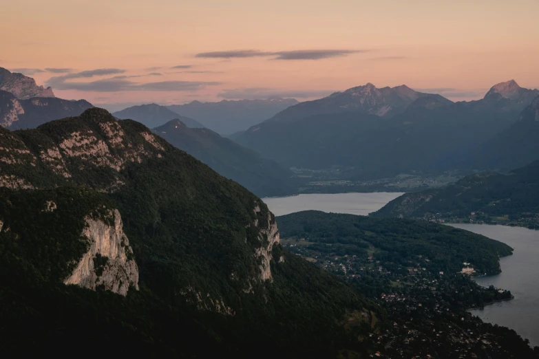 the view of mountains and a lake with water is shown from an overlook