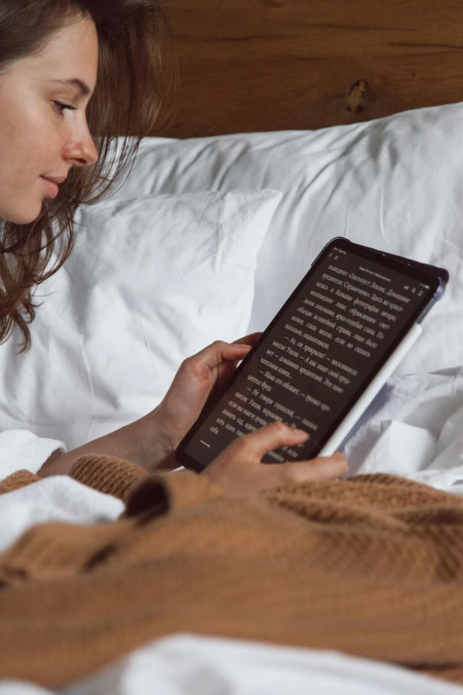 a girl reading a book in bed