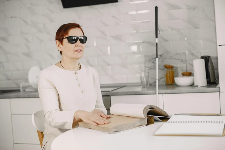 a woman wearing sunglasses sitting at a table