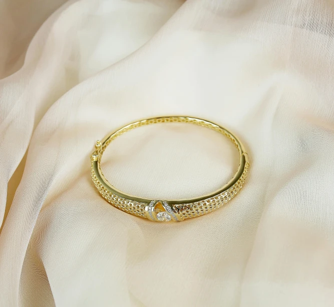 a gold ring sitting on a white satin