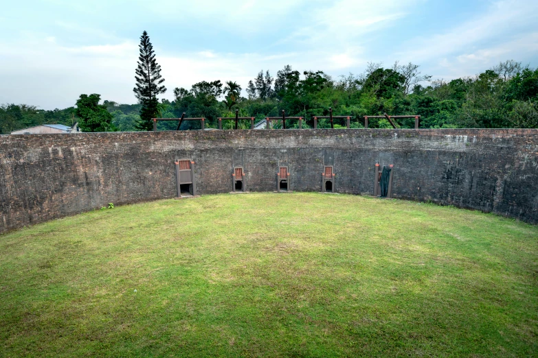 looking down on a wall built into an area with grass and bushes