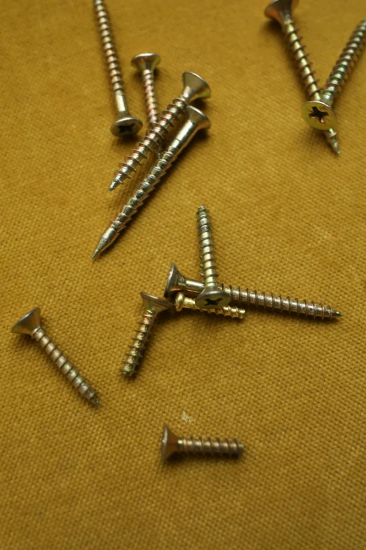 several screws and nails are laying on a cloth