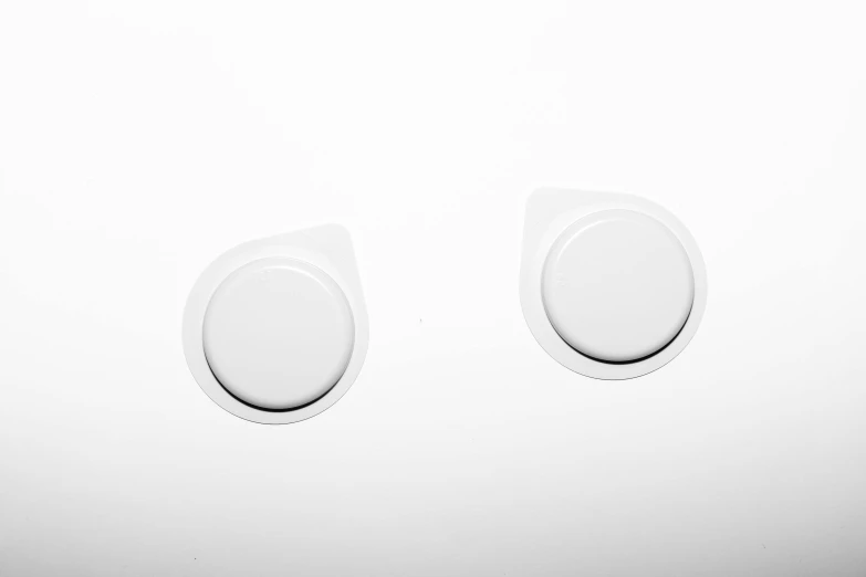 two round switches with three separate covers on a wall