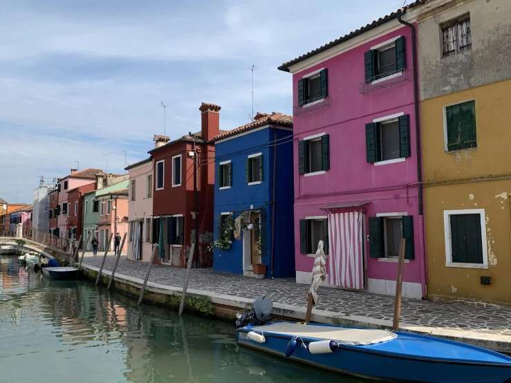 small rowboats are docked on the side of an urban waterway