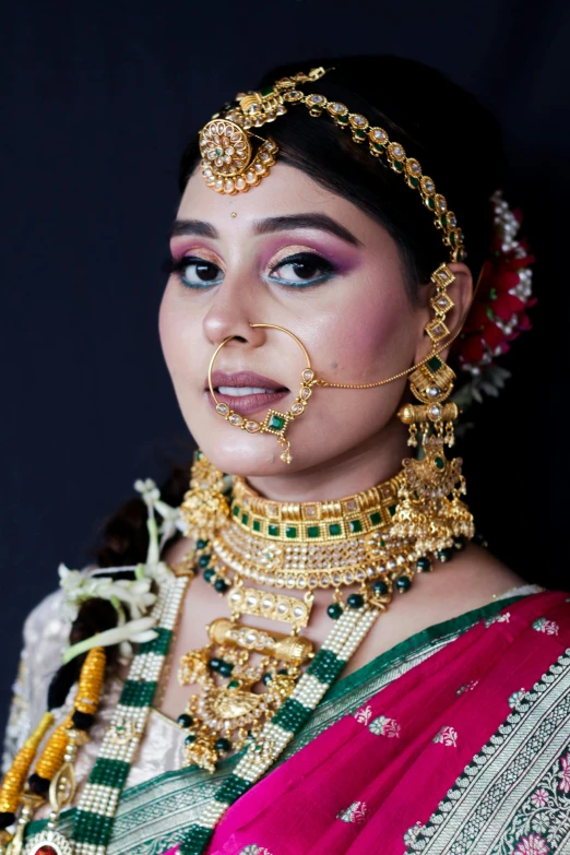 the woman with the golden jewelry is wearing a red sari