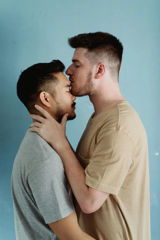 a woman that is kissing a man who is holding his cheek