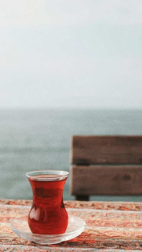 a bowl of soup on a table overlooking the ocean